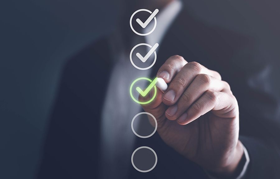 Image of a digital screen and a person making a tick mark in a list