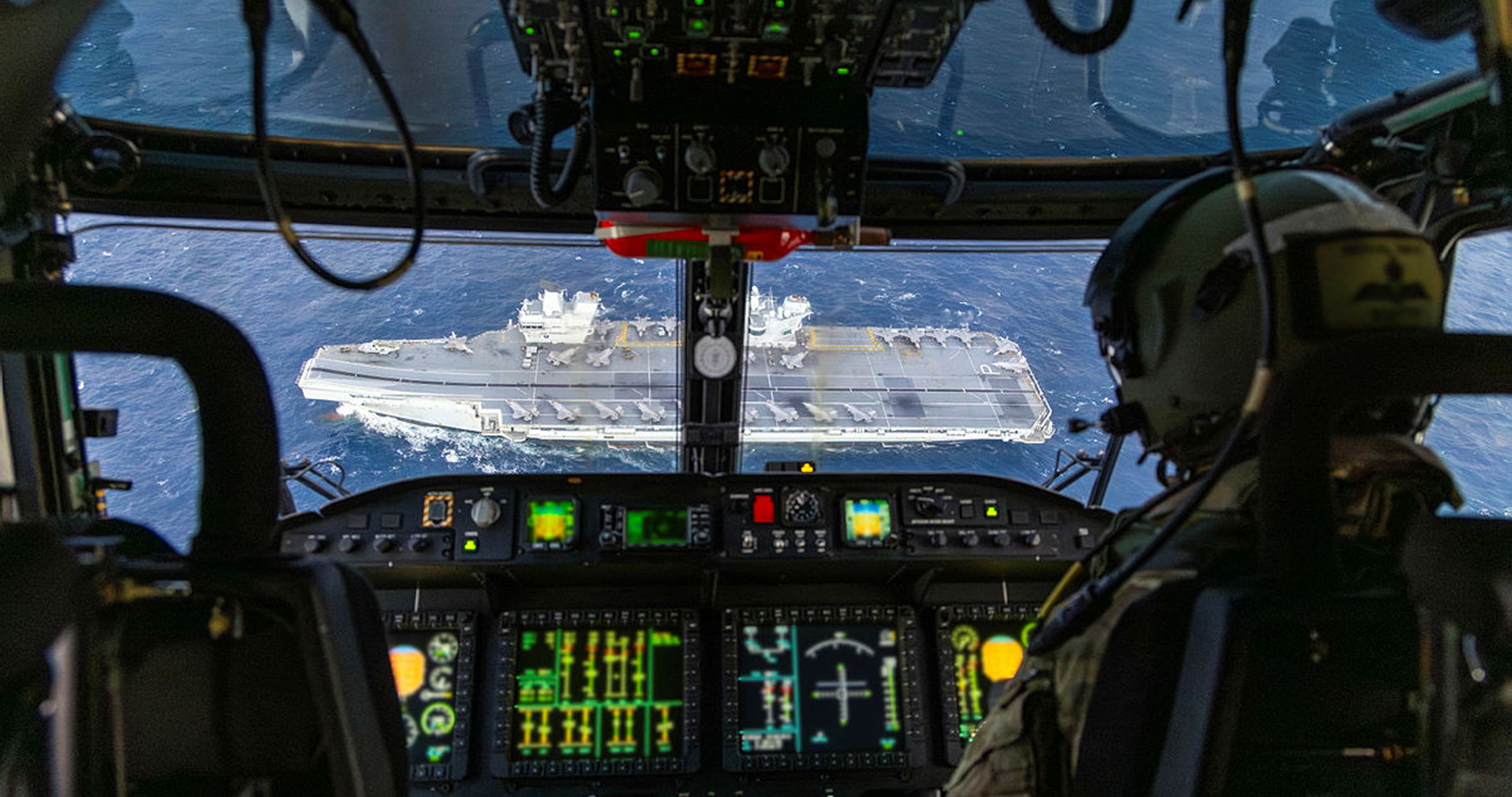 View from a military aeroplane cockpit with a military ship below