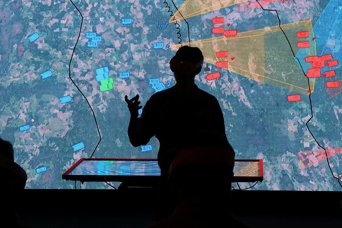 Image showing a the silhouette of a military officer looking at a screen view of a map showing positions of vehicles