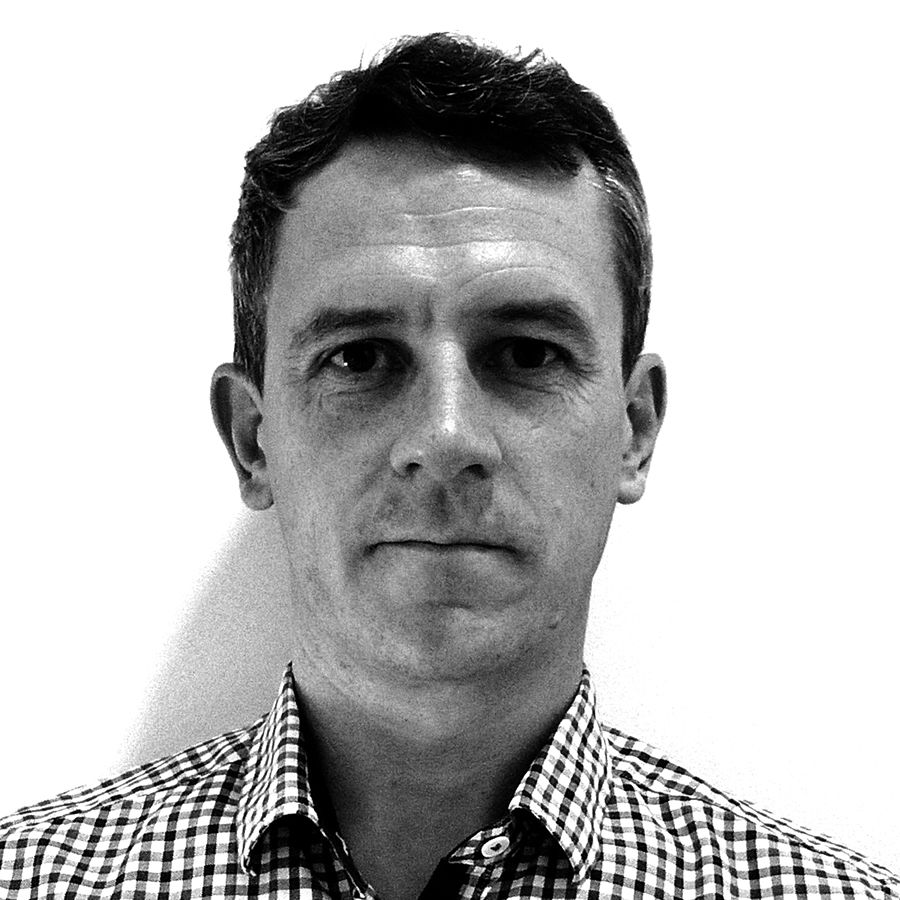 Headshot of a man in a checked shirt looking into the camera