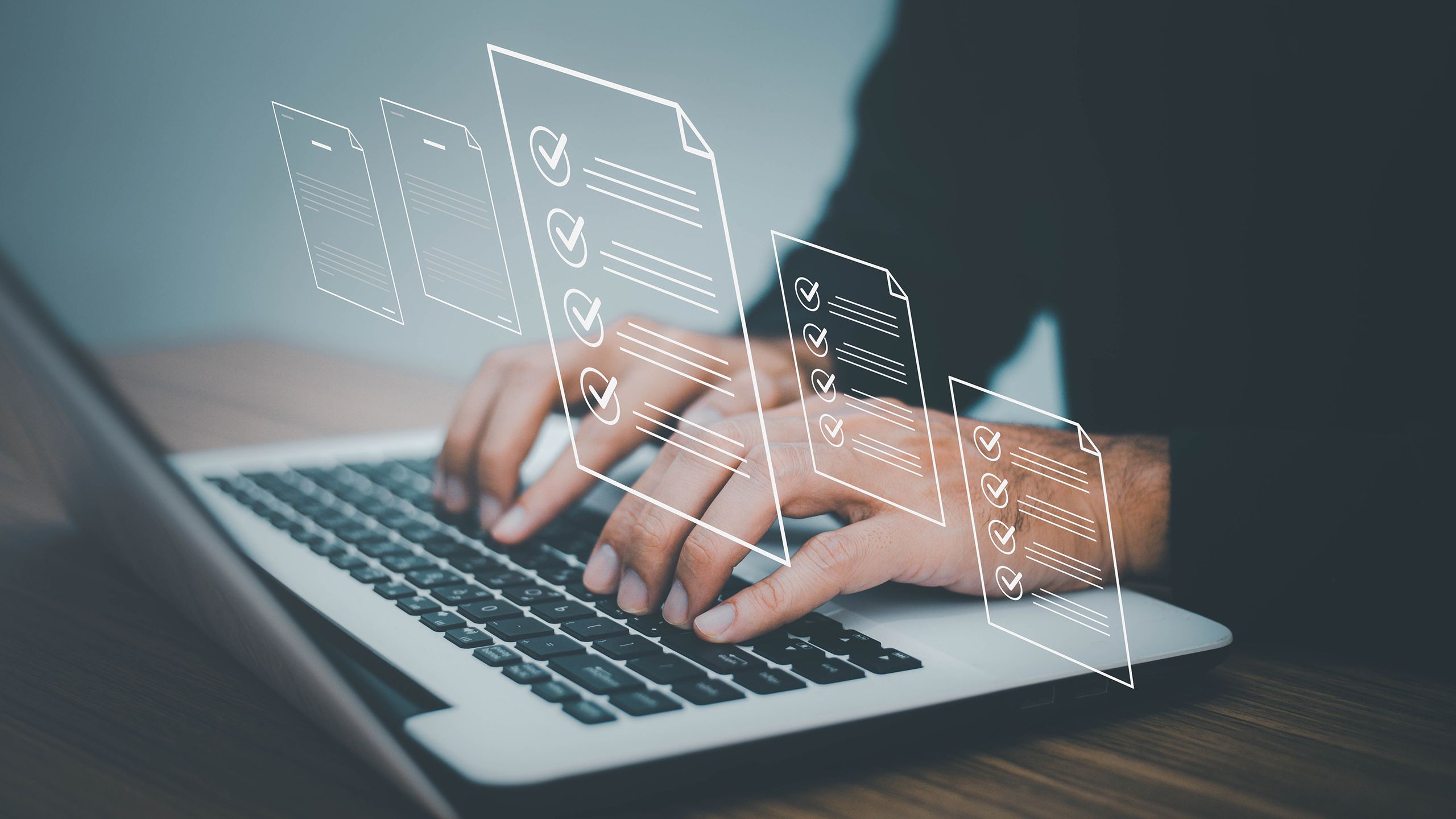 Image of a laptop and the hands of a business person working. We can see the charts they are working on projected from their laptop over the rest of the image
