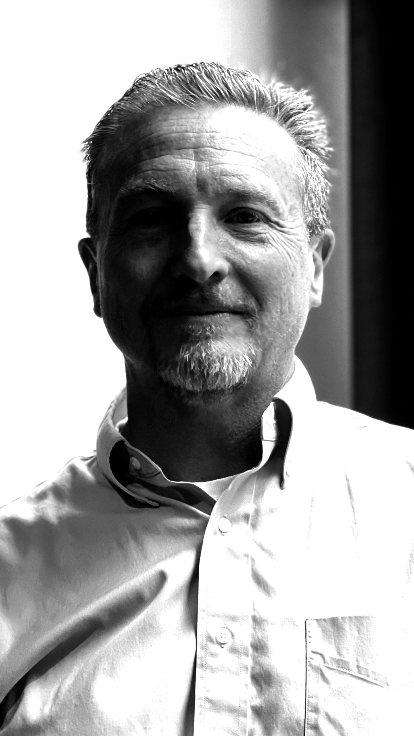 Head and shoulders image of a man in a suit facing into the camera