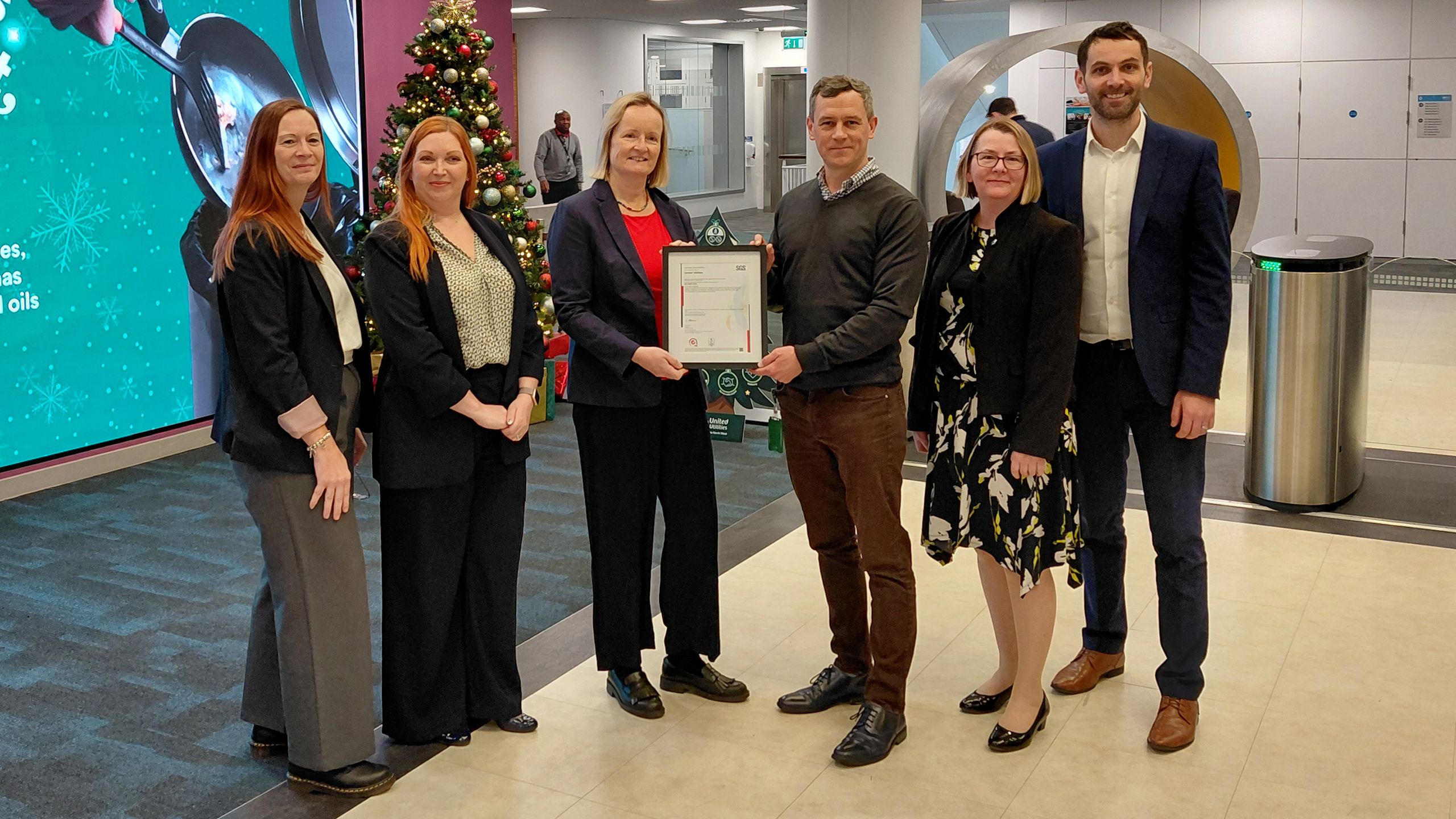 Image showing a group of six people standing up in a line with two of them holding a certificate